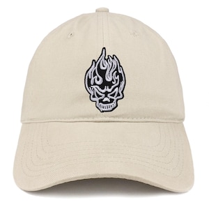 Puede incluir: Gorra de béisbol beige con un diseño bordado en blanco y negro de calavera y llamas. La gorra tiene una visera curva y una correa ajustable. La calavera y las llamas son el punto focal de la gorra.