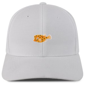 May include: A white baseball cap with an embroidered yellow and black fish design.