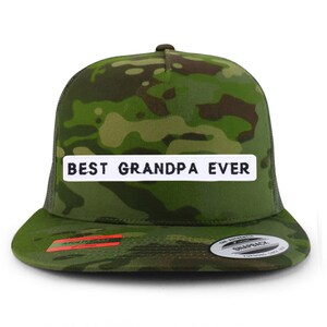 Puede incluir: Una gorra de camionero de camuflaje verde con un parche blanco que dice "BEST GRANDPA EVER" en letras negras.