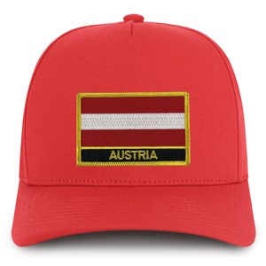 May include: Red baseball cap with a black and gold embroidered patch featuring the Austrian flag and the word "AUSTRIA".