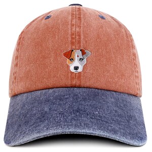 May include: A baseball cap with a distressed look. The cap features a rust-colored crown and a blue denim brim. An embroidered dog face is centered on the front. The cap has a curved brim and an adjustable strap.