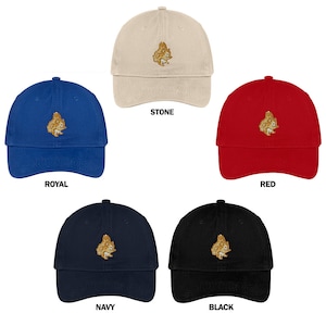 May include: Five baseball caps with an embroidered squirrel design. The caps are in the colours stone, royal blue, red, navy blue, and black.