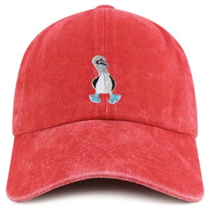 May include: Red baseball cap with an embroidered blue-footed booby bird design. The cap is made of a soft, textured material and features a curved brim. The bird is depicted in shades of gray, white, and blue.