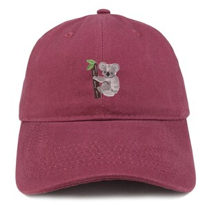 May include: A burgundy baseball cap with an embroidered koala bear sitting on a tree branch.