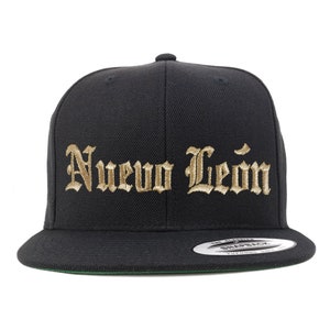 May include: Black and gold embroidered baseball cap with the text "Nuevo Leon" in a gothic font.