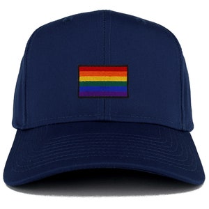 Pode incluir: Um boné de beisebol azul marinho com uma bandeira do arco-íris bordada na frente.