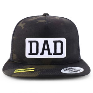 May include: A black and green camouflage trucker hat with a white patch that says "DAD" in black letters.