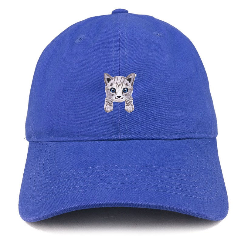 以下が含まれることがあります： ロイヤルブルーのベースボールキャップに、グレーとホワイトの小さな子猫の刺繍が施されています。子猫は青い目をしています。