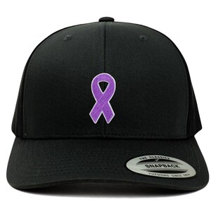 Puede incluir: Gorra snapback negra con un parche de cinta morada de concienciación. La gorra tiene una visera curva y una parte trasera de malla. El cierre a presión es visible en la parte trasera. Estilo clásico y casual.