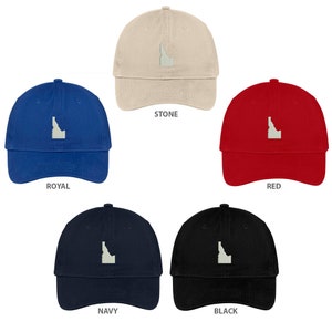 Może przedstawiać: Pięć czapek bejsbolowych z haftowanym obrysem stanu Idaho. Czapki są w kolorach kamiennym, królewskim niebieskim, czerwonym, granatowym i czarnym.