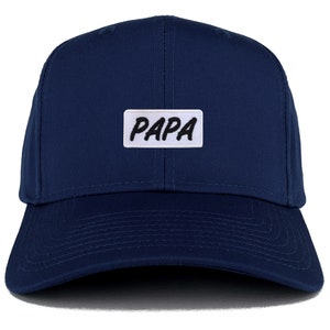 Puede incluir: Una gorra de béisbol azul marino con un parche blanco que dice "PAPA" en letras negras.