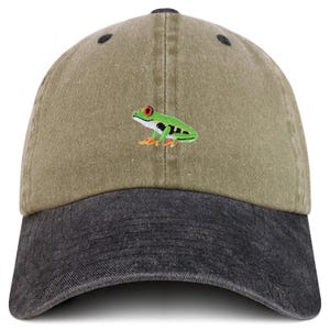 Könnte beinhalten: Zweifarbige Baseballkappe mit gesticktem Frosch. Die Kappe hat eine khakifarbene Krone und einen schwarzen Schirm. Der Frosch ist grün mit roten Augen und orangefarbenen Füßen. Die Kappe hat einen gebogenen Schirm und einen Knopf oben.