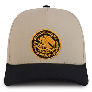 May include: A beige and black baseball cap with an embroidered patch featuring the coat of arms of Mexico and the text "GUADALAJARA".