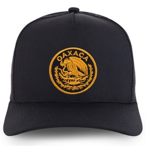 May include: Black trucker hat with a gold embroidered emblem featuring an eagle and the word "OAXACA".