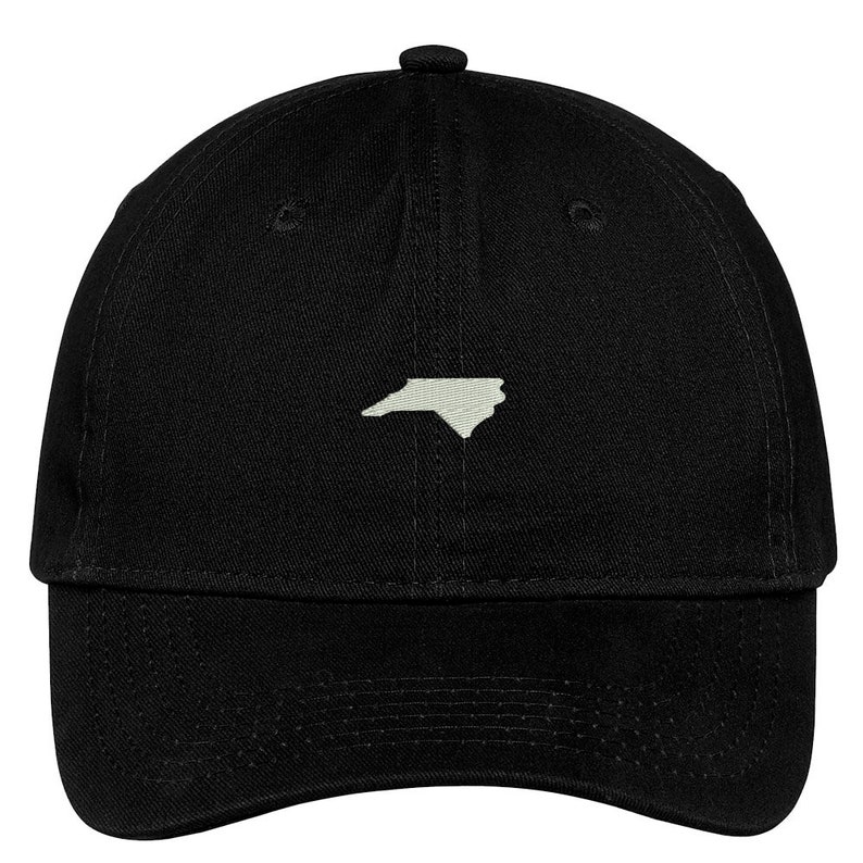 Puede incluir: Una gorra de b&eacute;isbol negra con un contorno blanco del estado de Carolina del Norte en la parte delantera.