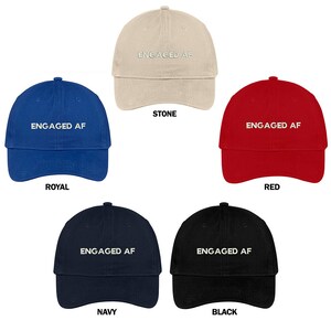 Puede incluir: Cinco gorras de béisbol en diferentes colores: piedra, azul real, rojo, azul marino y negro. Cada gorra tiene el texto "ENGAGED AF" bordado en la parte delantera en blanco.