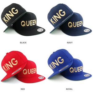 Puede incluir: Dos gorras de béisbol, una con la inscripción "KING" en letras doradas y la otra con la inscripción "QUEEN" en letras doradas. Las gorras están disponibles en cuatro colores: negro, azul marino, rojo y azul real.