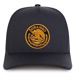 Könnte beinhalten: Eine schwarze Trucker-Kappe mit einem goldenen gestickten Logo, auf dem "DURANGO" steht und ein stilisierter Adler mit einer Schlange in seinen Krallen abgebildet ist.