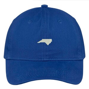 Puede incluir: Una gorra de b&eacute;isbol azul real con un contorno blanco del estado de Carolina del Norte en la parte delantera.