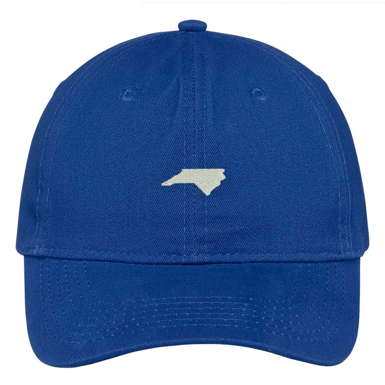 Puede incluir: Una gorra de b&eacute;isbol azul real con un contorno blanco del estado de Carolina del Norte en la parte delantera.