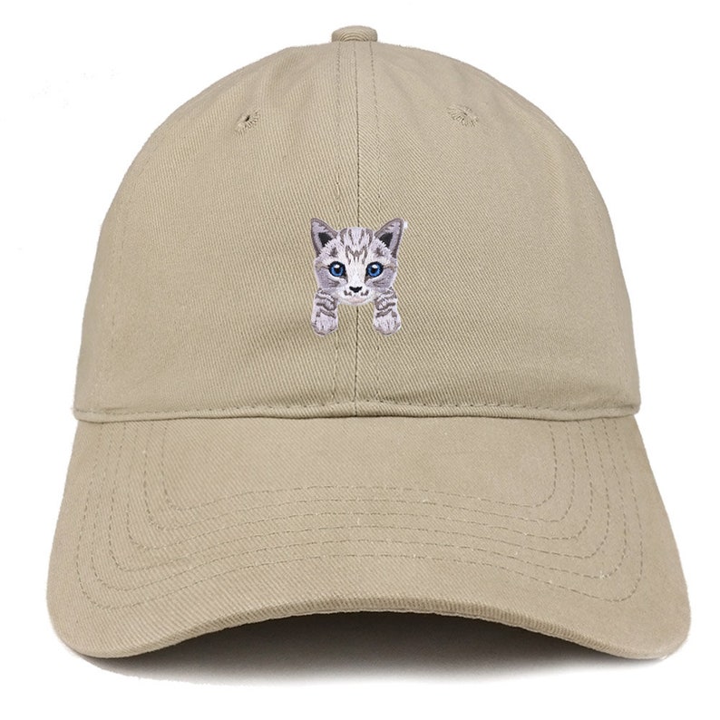 以下が含まれることがあります： 青い目をした灰色と白の猫の刺繍が施されたベージュの野球帽