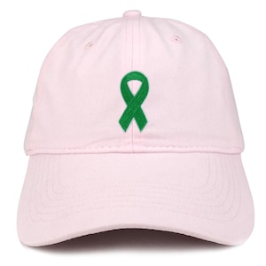 May include: A pale pink baseball cap featuring a green ribbon emblem. The cap has a curved peak and an adjustable strap. The hat is made from a soft, cotton-like fabric.