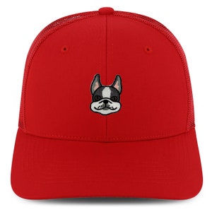 Op de afbeelding: Rode trucker cap met een geborduurd Frans bulldog gezicht in zwart en wit.