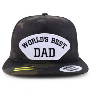 Peut inclure: Un chapeau de camionneur camouflage noir et vert avec un patch blanc qui dit "World's Best Dad" en lettres noires.