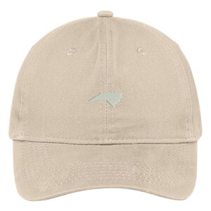 Puede incluir: Una gorra de b&eacute;isbol beige con un contorno bordado del estado de Carolina del Norte en verde claro.