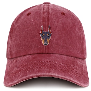 May include: A red, distressed, cotton baseball cap with an embroidered image of a Doberman Pinscher dog's face.