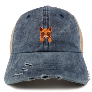 May include: A distressed denim trucker hat with a tan mesh back and a small embroidered orange cat face on the front. The hat has a curved brim and distressed details.