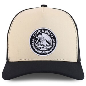 Könnte beinhalten: Eine beige und schwarze Trucker-Kappe mit einem schwarzen und weißen gestickten Logo, auf dem "DURANGO" steht und ein stilisierter Adler mit einer Schlange in seinen Krallen abgebildet ist.