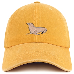 May include: A yellow baseball cap with an embroidered image of a brown sea lion.