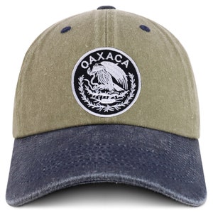 May include: A green and blue baseball cap with a white embroidered patch that says "OAXACA" and features a stylized eagle with a snake in its beak.