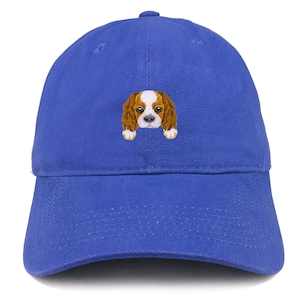 May include: A royal blue baseball cap with an embroidered image of a Cavalier King Charles Spaniel puppy.