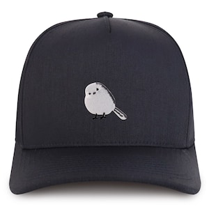 Puede incluir: Una gorra de béisbol azul oscuro con un diseño de pájaro blanco bordado.
