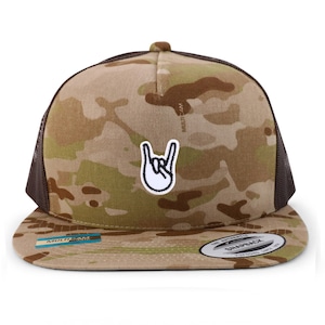 Puede incluir: Una gorra de camionero de camuflaje marrón, negro y verde con un parche blanco de una mano haciendo el gesto de rock and roll. La gorra tiene una parte trasera de malla negra y una visera marrón con una etiqueta "MULTICAM". La gorra también tiene una etiqueta "The Authentic Snapback" en la parte posterior.