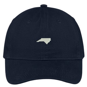 Puede incluir: Una gorra de b&eacute;isbol azul marino con un contorno blanco del estado de Carolina del Norte en la parte delantera.