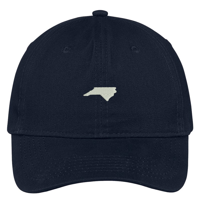 Puede incluir: Una gorra de b&eacute;isbol azul marino con un contorno blanco del estado de Carolina del Norte en la parte delantera.
