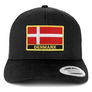 May include: Black trucker hat featuring the flag of Denmark. The flag is red with a white Scandinavian cross, and the word "DENMARK" is below it. The hat has a mesh back and a snapback closure.