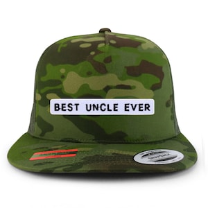 May include: A camouflage-patterned snapback hat with a flat brim and mesh back. The hat features a white rectangular patch with the text "BEST UNCLE EVER" in black block letters. The hat is predominantly green, brown, and tan.