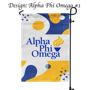 Può includere: Una bandiera da giardino bianca con un design astratto blu e giallo. La bandiera presenta il testo "Alpha Phi Omega" e un logo di fiamma blu e giallo. La bandiera è attaccata a un palo di metallo nero.
