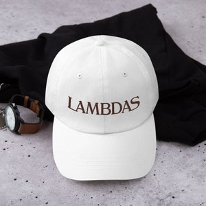 May include: White baseball cap with a brown embroidered logo that says "LAMBDAS".