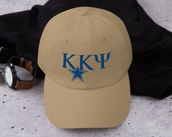 Könnte beinhalten: Beige Baseball Cap mit den griechischen Buchstaben KKY und einem blauen Stern-Emblem auf der Vorderseite gestickt. Die Kappe hat einen gebogenen Schirm und einen Stoffriemenverschluss. Hergestellt aus weichem, strapazierfähigem Material.