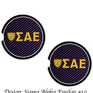 Könnte beinhalten: Zwei runde Getränkeuntersetzer mit schwarzem Rand. Die Untersetzer haben ein lila-schwarzes diagonales Streifenmuster. In der Mitte befinden sich die griechischen Buchstaben ΣAE in Gold, mit einem goldenen Schildemblem. Der Text "Design: Sigma Alpha Epsilon #10" steht unten.