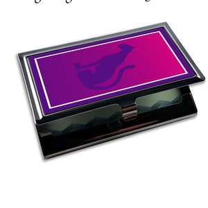 Peut inclure: Un porte-cartes de visite argenté avec un design dégradé violet et rose mettant en scène une silhouette noire de chat. Le texte "Design: Sigma Lambda Gamma #1" est imprimé en haut du porte-cartes.