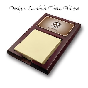 Könnte beinhalten: Ein Holz-Schreibtisch-Organizer mit einem Notizblock und einer braunen Plakette mit dem Text "Lambdas Est. 1923" und einem Logo einer Sonne mit einem Dreieck darin.