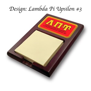 Könnte beinhalten: Ein Holz-Notizblockhalter mit einem roten und gelben Aufkleber, auf dem "ΑΠΥ Lambda Pi Upsilon Sorority, Latinas Poderosas Unidas, Inc." steht.