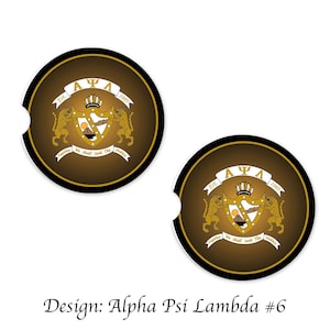Op de afbeelding: Twee ronde zwarte en gouden onderzetters met de Griekse letters Alpha Psi Lambda, een wapenschild en de tekst "Est. 1985. Samen zoeken we het edele" in goud.
