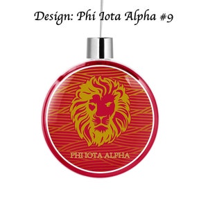 Peut inclure: Boule de Noël rouge et or avec un motif de tête de lion et le texte "PHI IOTA ALPHA".